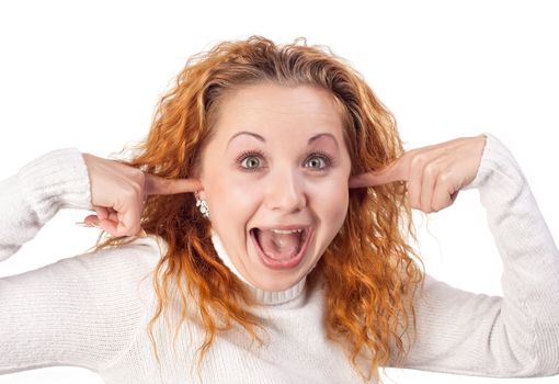 Surprised redhead  girl closes her ears by hands