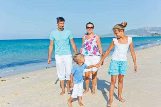 Family of four having fun on tropical beach