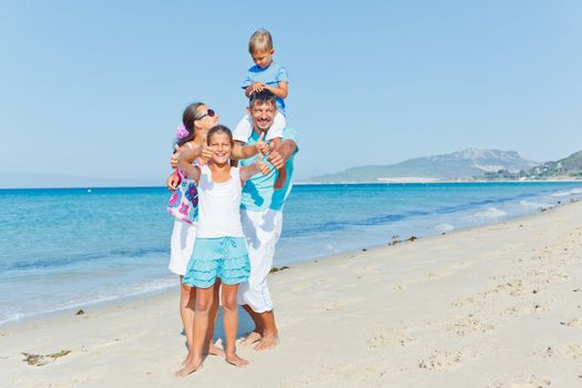 Family of four having fun on tropical beach