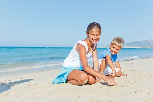 Two cute kids playing on tropical beach