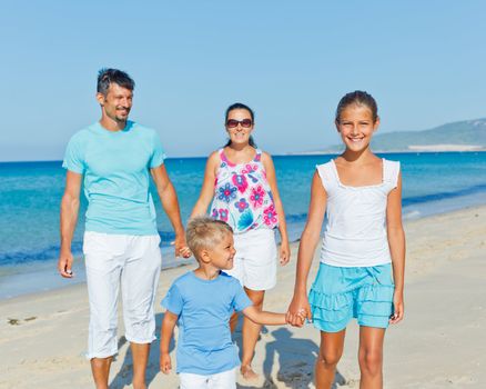 Family of four having fun on tropical beach