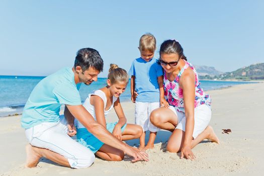 Family of four having fun on tropical beach