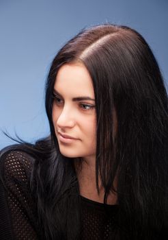 close up portrait of a brunette beautiful girl on blue