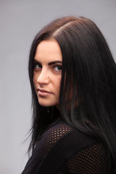 close up portrait of a brunette beautiful girl on gray