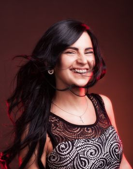 Beautiful smiling young woman with hair blowing on wind