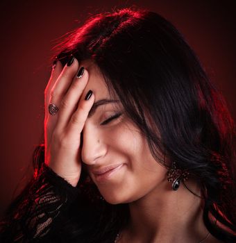 young woman hides her face by hand and smiles