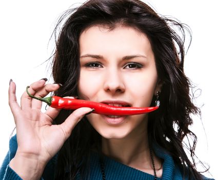 young lady holding red hot chili pepper in mouth