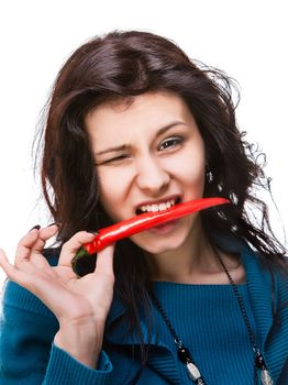young lady holding red hot chili pepper in mouth