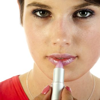 a young women is applying her lips with pink lipstick