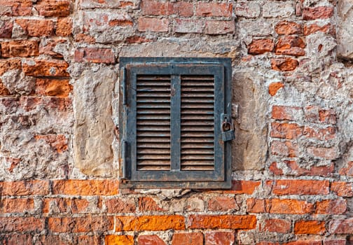 Rusty metal window on an old brick wall