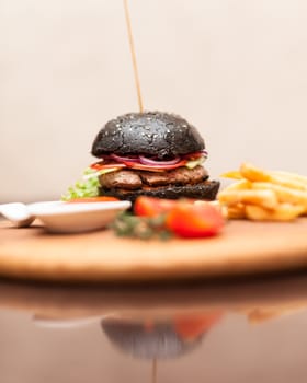 Delicacy. Delicious black hamburger with squid ink. Shallow DOF. Focus on the burger