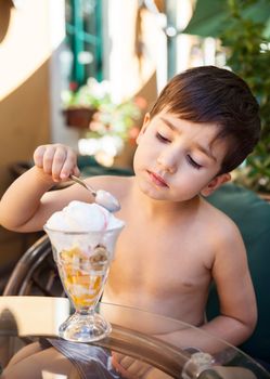 Portrait of 4-5 years old boy eating ice cream dessert
