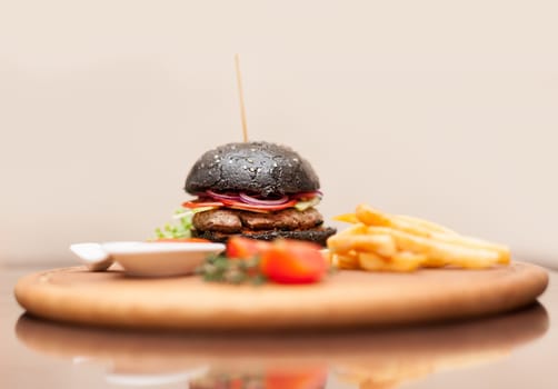 Delicacy. Delicious black hamburger with squid ink. Shallow DOF. Focus on the burger