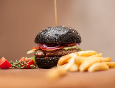 Delicacy. Delicious black hamburger with squid ink. Shallow DOF. Focus on the burger