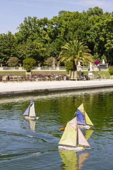 Traditional small wooden sailing boat in the pond of park Jardin du Luxembourg, Paris, France