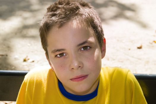 Cute boy smiling at camera in the park on a sunny day