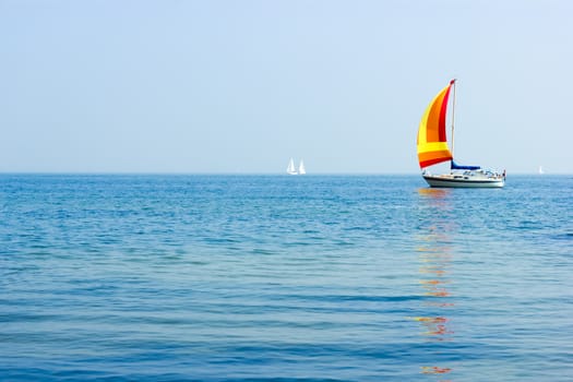 Seascape with sailboat the background of the blue sky.