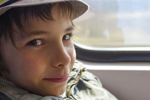 Handsome smiling boy rides on a train