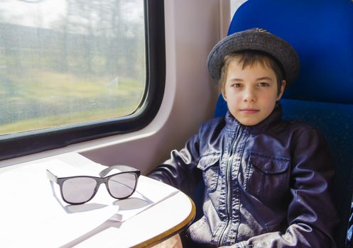 Handsome boy with sunglasses rides on a train