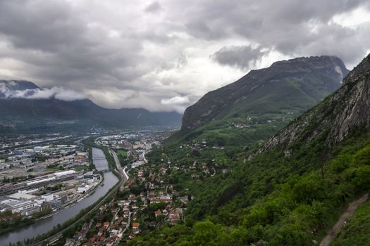 panorama of Grenoble with Alps and deep clouds in background