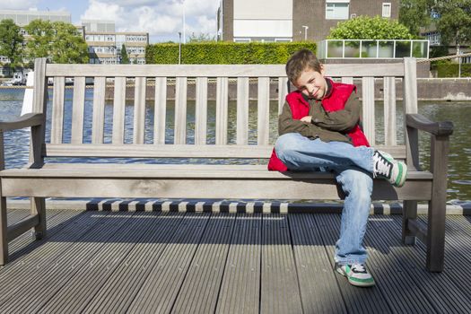 Cute boy sitting on a bench