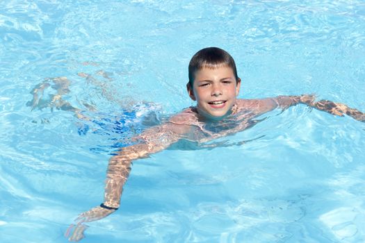 Activities on the pool. Cute boy swimming and playing in water in swimming pool