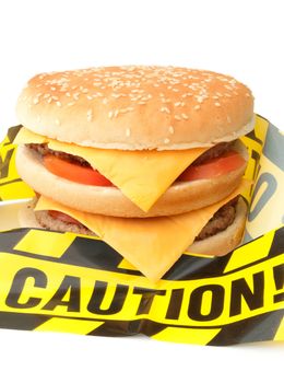 Caution tape wrapped around double cheeseburger 