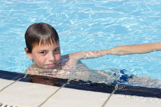 Activities on the pool. Cute boy swimming and playing in water in swimming pool