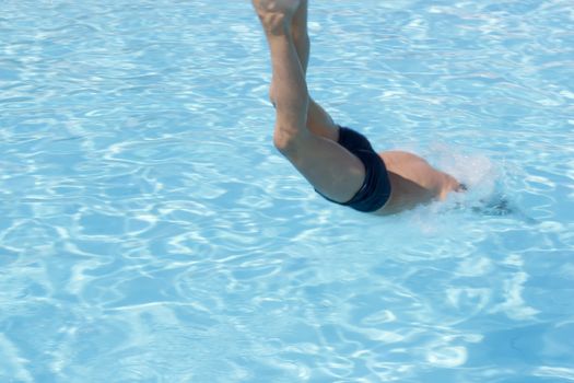 Activities on the pool. Boy diving in swimming pool