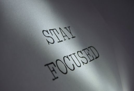 Light centred on the words stay focused motivational phrase 