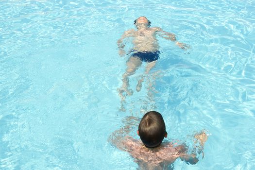 two happy friends swimming in the pool