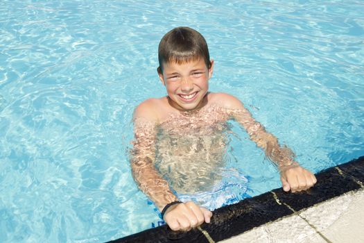 Activities on the pool. Cute boy swimming and playing in water in swimming pool
