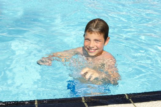 Activities on the pool. Cute boy swimming and playing in water in swimming pool