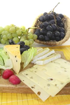 Slices of cheese with grapes, lettuce and radishes