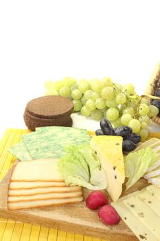 Slices of cheese with grapes, radishes and bread