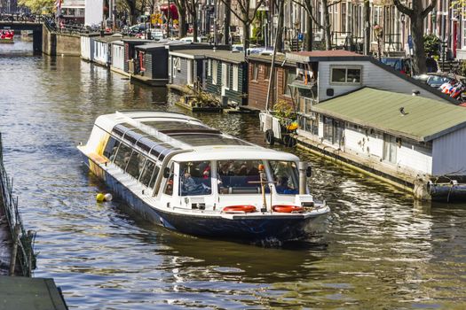 View on the houseboats with cruiseboat in Amsterdam the Netherlands