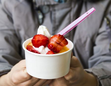 boy offers ice cream(strawberry topping)