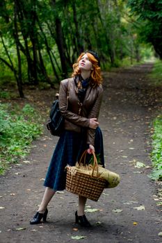 Portrait of a beautiful redhair girl in the autumn park. Caucasian race.