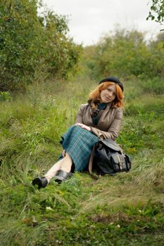 Portrait of a beautiful redhair girl in the autumn park. Caucasian race.