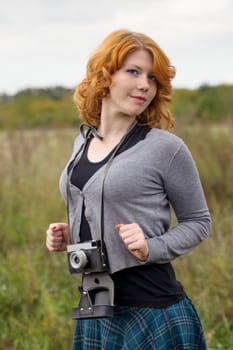 Portrait of a beautiful redhair girl in the autumn park. Caucasian race.