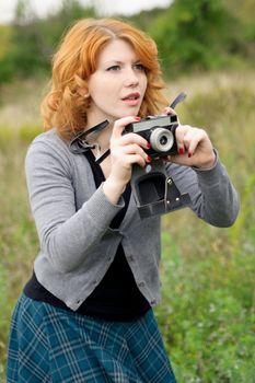 Portrait of a beautiful redhair girl in the autumn park. Caucasian race.