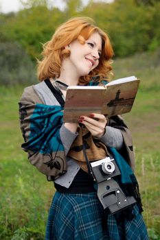 Portrait of a beautiful redhair girl in the autumn park. Caucasian race.