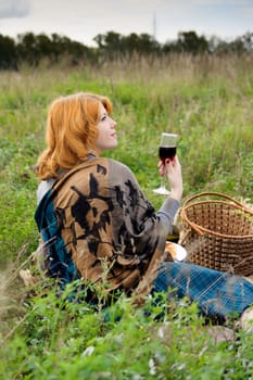 Portrait of a beautiful redhair girl in the autumn park. Caucasian race.