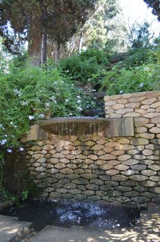 Pretty small street waterfall in a urban park in the centre of Barcelona,Spain.