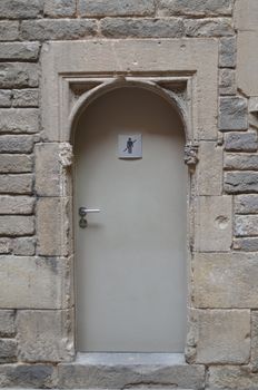 A simple wooden door with a men only sign attached.