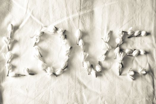 Love written with small  flowers on a honeymoon bed linen
