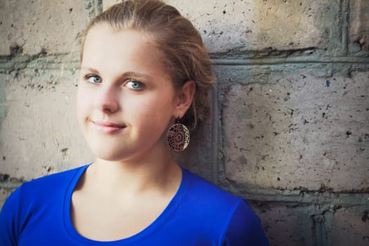 Young Blue-Eyed Girl Near Brick Wall