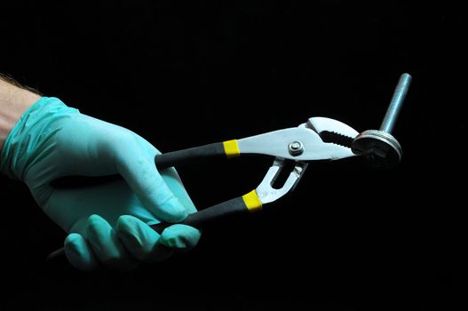 Pliers and a Hand on a Black Background