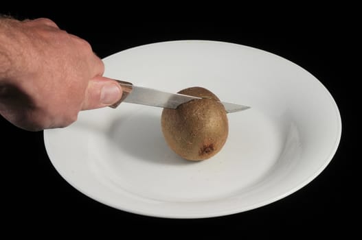 Cutting a Green and Brown Kiwi in Two Parts