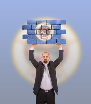 Businessman holding a large piece of a brick wall, flag of Minnesota, isolated on national flag